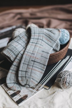 El örgüsü çoraplar, iğneler ve iplik yumağı sepette. El yapımı ve yavaş yaşam için higge kavramı.