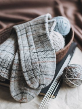 El örgüsü çoraplar, iğneler ve iplik yumağı sepette. El yapımı ve yavaş yaşam için higge kavramı.