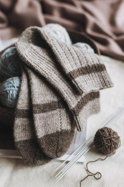 El örgüsü çoraplar, iğneler ve iplik yumağı sepette. El yapımı ve yavaş yaşam için higge kavramı.