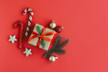 Kırmızı arka planda Noel süsleri olan hediye kutusu. Tatil konsepti. Metin için yer.