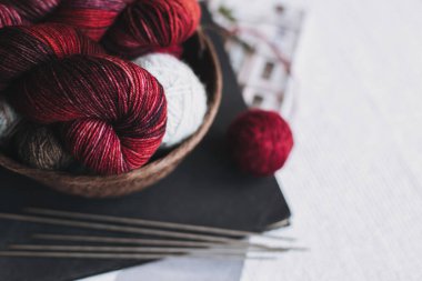 Skeins and balls of wool yarn for hand knitting in a basket. Concept for handmade. Place for text.