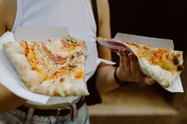 Elinde lezzetli İtalyan pizzası olan bir kız. Seçici odak.