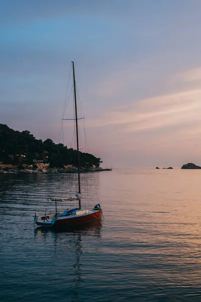 Hırvatistan 'ın Dubrovnik kenti yakınlarındaki denizde gün batımında güzel kırmızı bir tekne. Hırvatistan 'da seyahat hedefi.