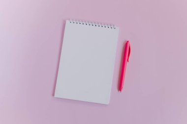 Boş sayfası ve pembe arka planı olan bir defter. Düz yatıyordu. Metin için yer.