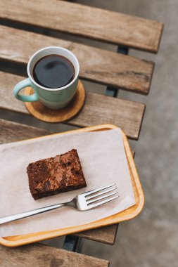 Bir fincan sade kahve ve sokak kafesindeki bir masada kek. Metin için yer.