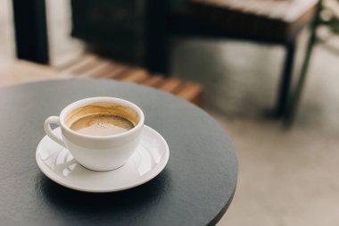 Sokak kafesindeki bir masada bir fincan sade kahve. Metin için yer.