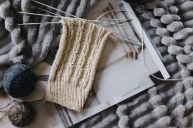 Elle örülmüş çoraplar, iğneler ve iplik yumağı. El yapımı ve yavaş yaşam için higge kavramı.