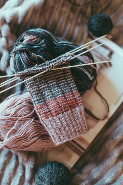 Elle örülmüş çoraplar, iğneler ve iplik yumağı. El yapımı ve yavaş yaşam için higge kavramı.