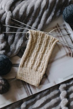 Elle örülmüş çoraplar, iğneler ve iplik yumağı. El yapımı ve yavaş yaşam için higge kavramı.