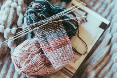 Elle örülmüş çoraplar, iğneler ve iplik yumağı. El yapımı ve yavaş yaşam için higge kavramı.