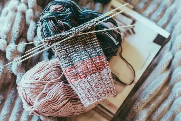 Elle örülmüş çoraplar, iğneler ve iplik yumağı. El yapımı ve yavaş yaşam için higge kavramı.