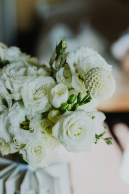 Yumuşak bir düğün buketi beyaz çiçekler Freesia, sabah güneşinde güller. Seçici odak.
