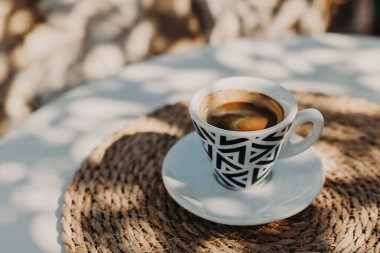 Güneşli bir sabahta bir sokak kafeteryasında bir fincan sade kahve. Seçici odaklanma. Metin için yer.