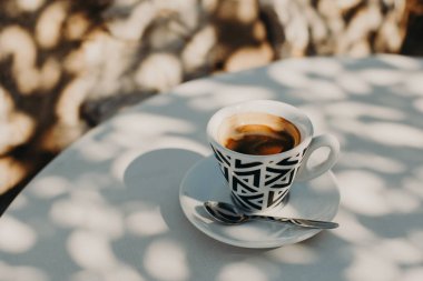 Güneşli bir sabahta bir sokak kafeteryasında bir fincan sade kahve. Seçici odaklanma. Metin için yer.