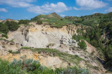 Theodore Roosevelt National Park of North Dakota, shown here during a summer day with cumulus clouds in the sky, is where the Great Plains meet the rugged Badlands. 