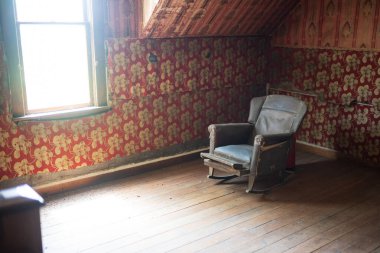 Pryor, MT, USA, Jun 24, 2022: Pryor, MT, USA, Jun 24, 2022: Chief Plenty Coups State Park, former home of the last Crow Chief is Billings. An antique chair found in a room with vintage wallpaper.