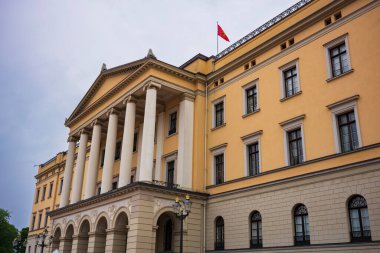 Oslo, Norveç, 20 Haziran 2023: Turistler fırtınalı bir günde Kraliyet Sarayı 'nı ziyaret ettiler. Burası monarşinin işlediği yerdir. Kral, Konsey 'e ve Kral ve Kraliçe' nin yaşadığı yere başkanlık eder..