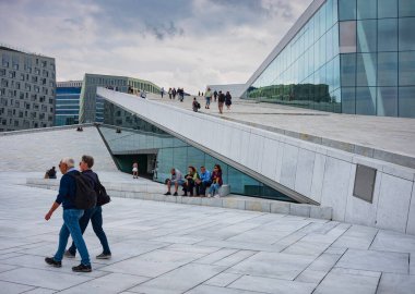 Oslo, Norveç, 19 Haziran 2023: Turistler, ziyaretçilere mermer kaplı çatısında yürüme olanağı sağlamak amacıyla 2008 yılında inşa edilen Oslo Opera Binası 'nı keşfediyorlar.. 