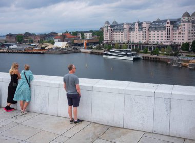 Oslo, Norveç, 19 Haziran 2023: Turistler, ziyaretçilere mermer kaplı çatısında yürüme olanağı sağlamak amacıyla 2008 yılında inşa edilen Oslo Opera Binası 'nı keşfediyorlar.. 