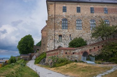 Norveç 'in Oslo kentindeki Akershus Kalesi, Orta Çağ' da şehri korumak ve bir kraliyet konutu sağlamak için inşa edilmiştir. Bulutlu bir yaz gününde görünen taş kale.
