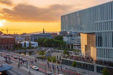 Oslo, Norveç, 20 Haziran 2023: Turistler Norveç 'in ilk ve en büyük kütüphanesi olan Oslo Halk Kütüphanesi' nden gün batımını izliyorlar. Modern kütüphanede sadece Deichman 'ın geniş kitap koleksiyonları var.. 