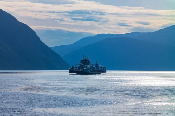 Patrons ride the auto ferry from Fodnes to Mannheller, Norway during a summer evening. There are 180 ferries that operate in Norway hauling traffic across the beautiful fjords.