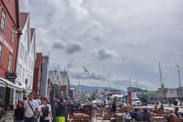 Bergen, Norveç - 29 Haziran 2023: Bryggen, Vogen limanının doğu tarafında sıralanan bir dizi Hanseatic mirası ticari binasıdır. Turistler sokakta yürürler..