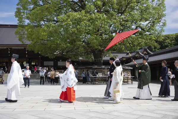 stock image Tokyo, Japan - Jun 15, 2024: A traditional Japanese wedding processional takes place at the Meiji Jingu Shrine in the heart of the city during a summer afternoon. 