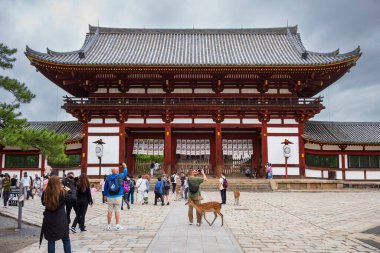 Nara, Japonya, 18 Haziran 2024: Antik Todaiji Tapınağı ve onun devasa Büyük Buda 'sı, burada insanlarla dolu bulutlu bir yaz günü resmedildi..  