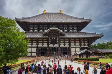 Nara, Japonya, 18 Haziran 2024: Antik Todaiji Tapınağı ve onun devasa Büyük Buda 'sı, burada insanlarla dolu bulutlu bir yaz günü resmedildi..  