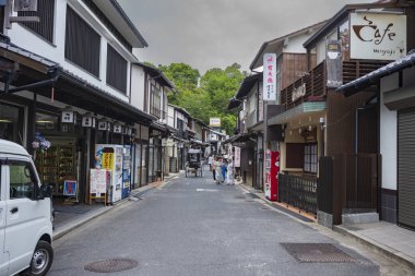 Itsukushima Jinja Tapınağı yakınlarındaki Miyajima Omotesand Alışveriş Sokağı 'nı gezen turistler, bulutlu bir günde.