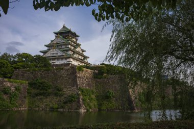 Osaka, Japonya, 23 Haziran 2024: Osaka Kalesi, günbatımında iç hendekten görülen Japonya 'nın en ünlü simgelerinden biridir..