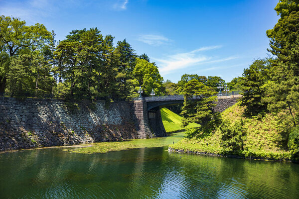 Tokyo, Japan - Jun 15, 2024: The Imperial Palace, the Nijubashi that are two bridges that form an entrance to the inner palace grounds and Kokyo Gaien, are visited by tourists during a summer day. 