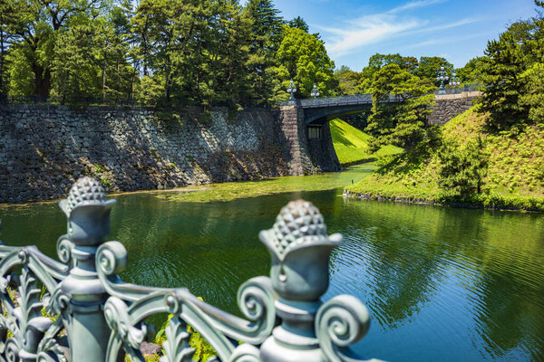 Tokyo, Japan - Jun 15, 2024: The Imperial Palace, the Nijubashi that are two bridges that form an entrance to the inner palace grounds and Kokyo Gaien, are visited by tourists during a summer day. 