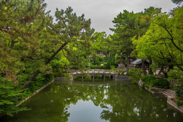 Osaka, Japonya - 25 Haziran 2024: Sumiyoshi Büyük Tapınağı, Sumiyoshi-ku 'da bir Shinto tapınağıdır ve tüm Sumiyoshi türbelerinin ana tapınağıdır. Yansımalı kemer köprüsü. 