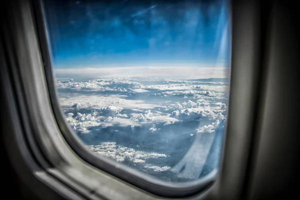 从飞机窗口看到蓝天和蓬松的云彩 — 图库照片