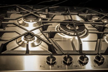 A closeup of details on the top side of a cooker in black and white
