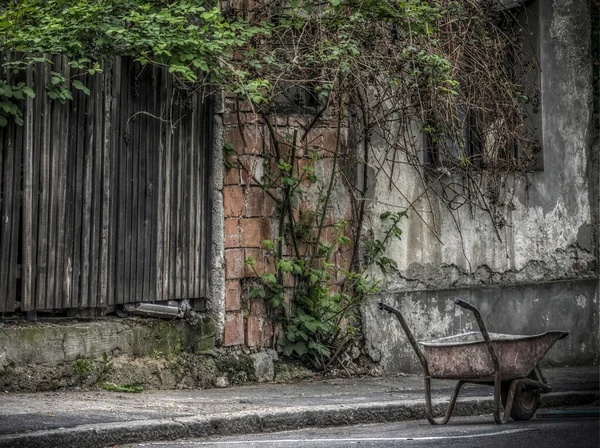 Abandoned builders cart in front of a ragged old building