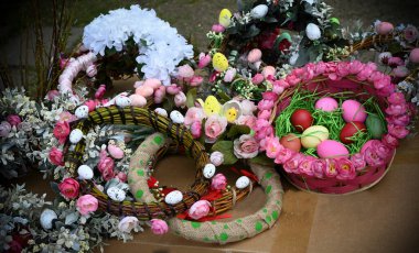 Çiçeklerle süslü Paskalya çelenkleri ve boyalı yumurtalar