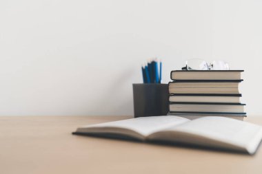 Masada kitap ve ders kitabı yığını var. Ticari başarı fikri öğrenme, planlama ya da çalışma. Eğitim kavramı ve bilgi kavramı. İş adamı ya da öğrenci eğitim becerisi