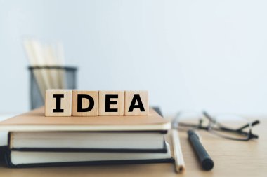Kitap ya da kitapla birlikte tahtadan küp ve IDEA. İş hayatı ya da eğitim başarı fikri. İş adamı ya da öğrenci bilgisi, yaratıcılık ve beceri gelişimi.