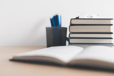 Masada kitap ve ders kitabı yığını var. Ticari başarı fikri öğrenme, planlama ya da çalışma. Eğitim kavramı ve bilgi kavramı. İş adamı ya da öğrenci eğitim becerisi