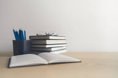 Masada kitap ve ders kitabı yığını var. Ticari başarı fikri öğrenme, planlama ya da çalışma. Eğitim kavramı ve bilgi kavramı. İş adamı ya da öğrenci eğitim becerisi