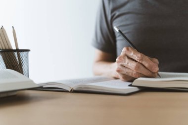 University student studying, writing and reading book or textbook. Learning or training skill course or classroom online at home. Idea of education success. Knowledge and cognition conceptual.