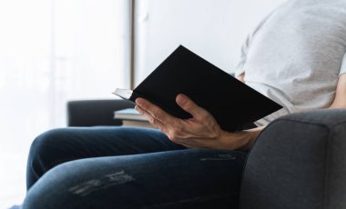 Üniversite öğrencisi evde ders çalışıyor ya da kitap öğreniyor, yazıyor ya da kitap okuyor. Bilgi ve beceri eğitimi evde çevrimiçi. Eğitim ve bilişsel başarı fikri