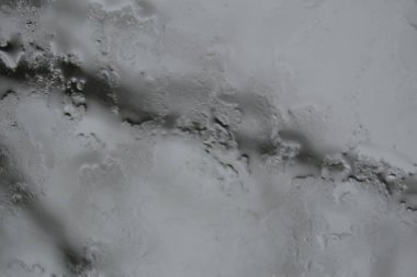 Abstraction. Branch silhouette through wet, rain-drenched glass.