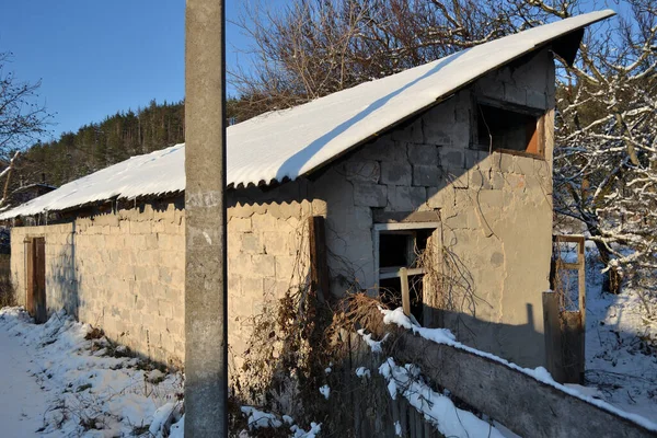 Old, abandoned, crumbling building in the village in winter