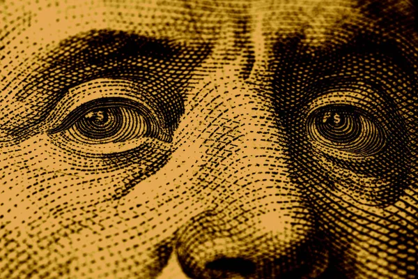 Close-up of Benjamin Franklin\'s eyes with a dollar sign in them close up.