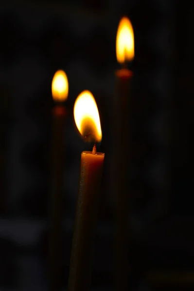 Candle fire on a dark background close up.