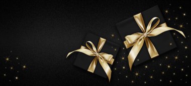 Siyah kutulu boş hediye kartı ve parlak altın kurdele yayı, parlak yıldızlı siyah arkaplanda izole edilmiş, alışveriş reklamları ve noel konsepti için üst manzara şablonu.